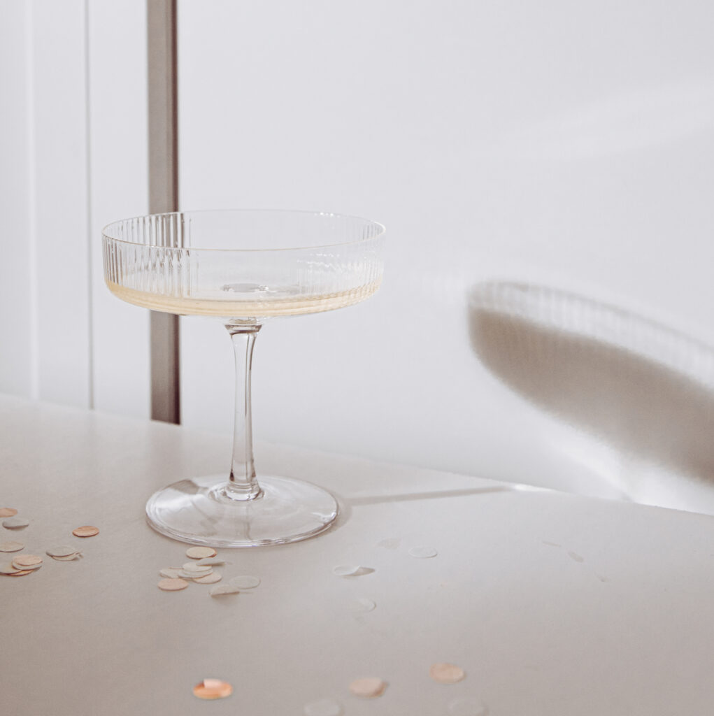 confetti and a glass of champagne, celebrating the holidays. Part of White and Gold New Year’s Eve Stock Photos by Haute Stock!