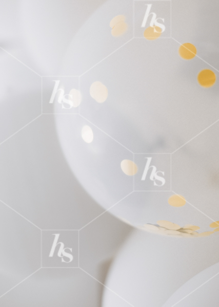 Close-up of gold confetti filled white balloons, featured in white& gold new year's eve stock photos collection for the holiday promotional sales.