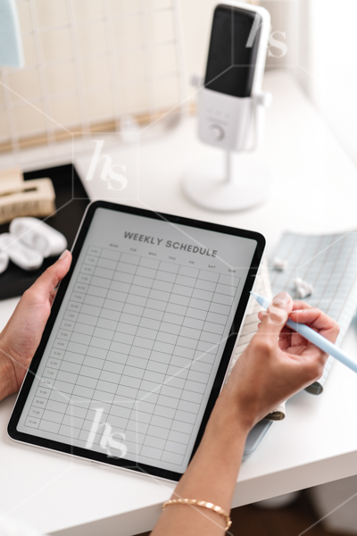 Stock image featuring a woman planning her weekly schedule on the iPad, part of modern blue workspace stock photos collection, Solopreneur by Haute Stock