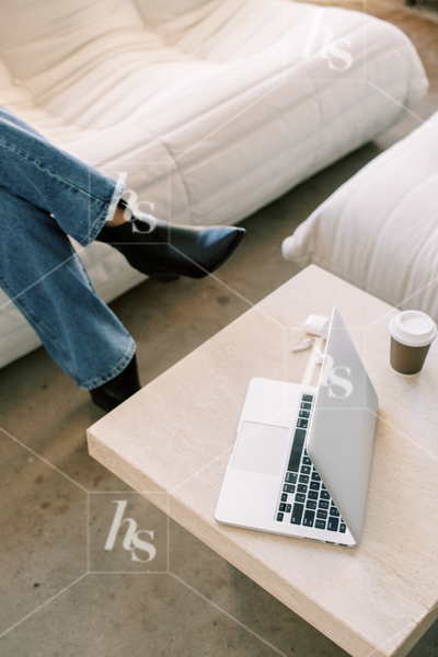 Stock image featuring woman sitting on couch with laptop in front of her, part of The Studio collection of elevated workspace stock photos and videos.