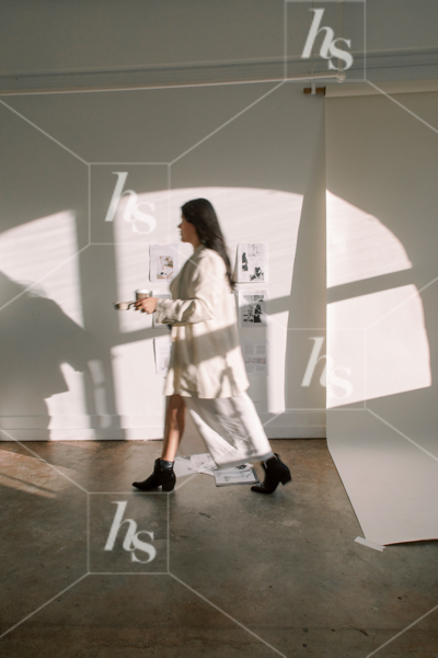 Stock image depicting Woman walking through studio set up for photoshoot, part of an  workspace stock photos and videos collection by Haute Stock