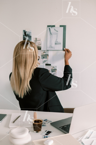 Woman placing image on wall for mood board part of Creative Brief stock videos & photos of women of color