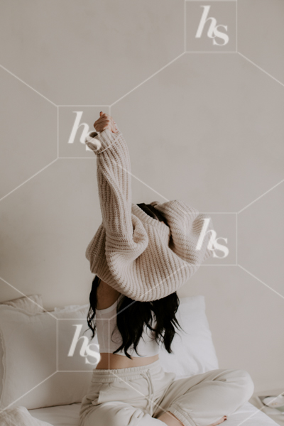 Woman putting on big comfy sweater, part of Daily Habits wellness & lifestyle stock images collection perfect to elevate your wellness brand!