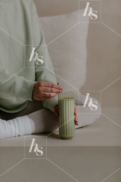 Woman stirring matcha in tall ribbed glass, part of Daily Habits wellness & lifestyle stock images collection perfect to elevate your wellness brand!