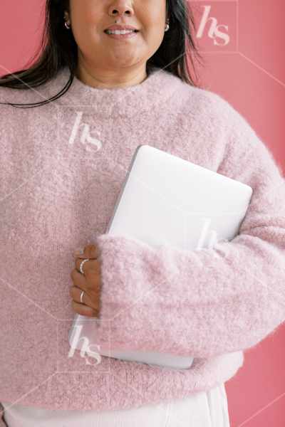 Woman in cute pink sweater holding laptop close to her, part of Millennial pink: feminine workspace stock videos collection.