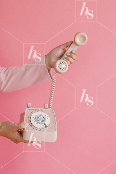 Woman holding receiver of a pink vintage phone part of Millennial pink: feminine workspace stock videos collection.