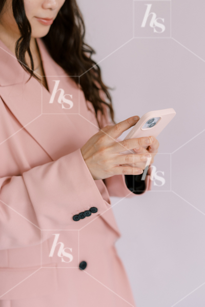 Woman in pink blazer typing on pink phone, part of Millennial pink: feminine workspace stock videos collection.