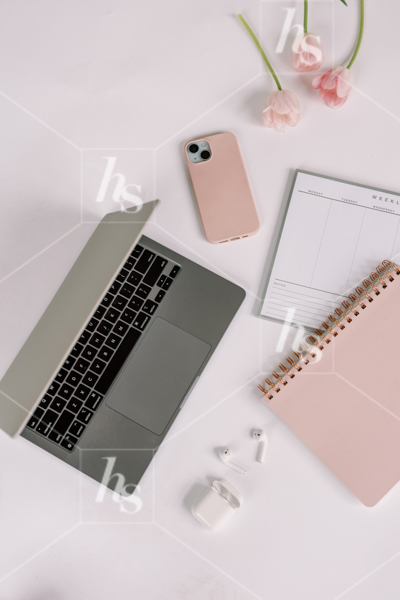 Laptop flatlay next to phone, notebook, and Airpods,  part of Millennial pink: feminine workspace stock videos collection.