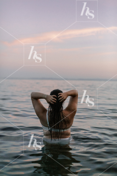 Woman stretching in the ocean water, part of Sips at Sunset a fun stock photos & videos collection by Haute Stock