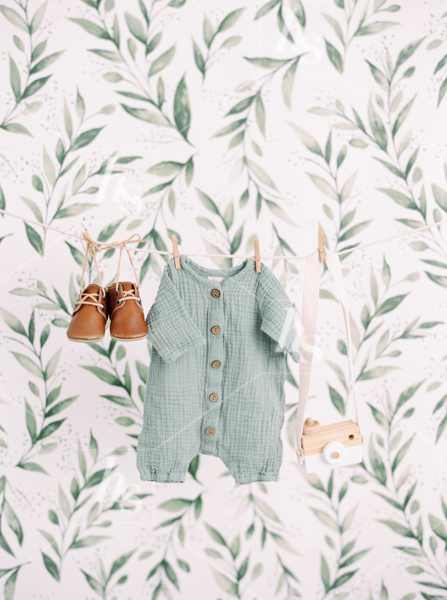 Vintage baby onesie, shoes, and camera hanging on clothing line, part of Nursery baby stock photos collection