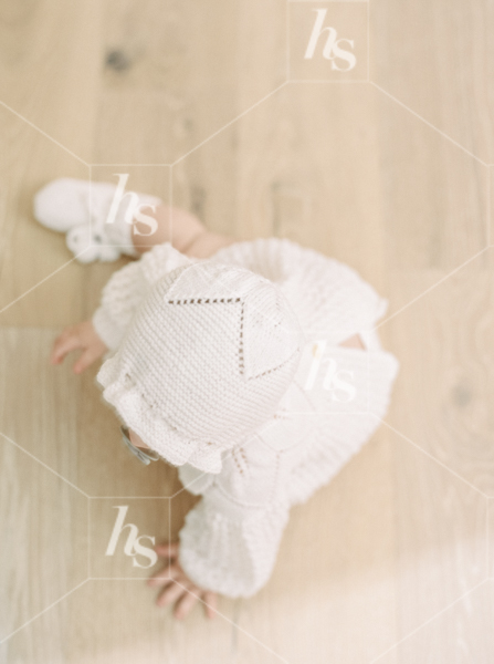 Overhead shot of baby in white knit outfit, part of Nursery baby stock photos collection