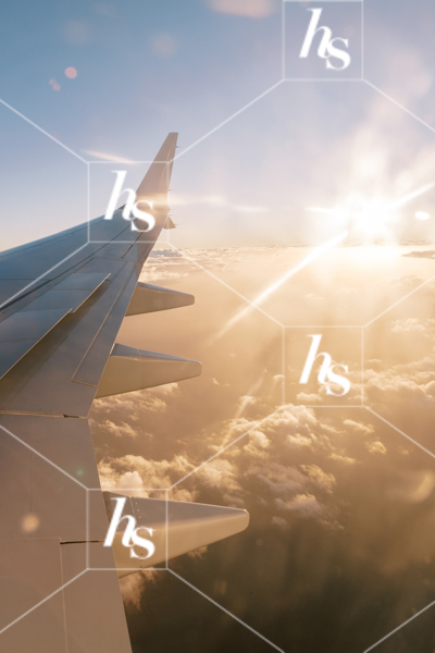 Going on vacation, an image of an airplane wing in the sky with sun and clouds, part of Digital Nomad seasonal travel & lifestyle stock photos and videos collection by Haute stock