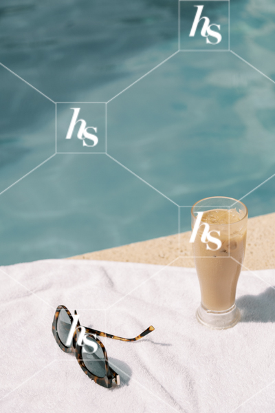 A image of cold drink and sunglasses by the poolside, part of Digital Nomad seasonal travel & lifestyle stock photos and videos collection by Haute stock