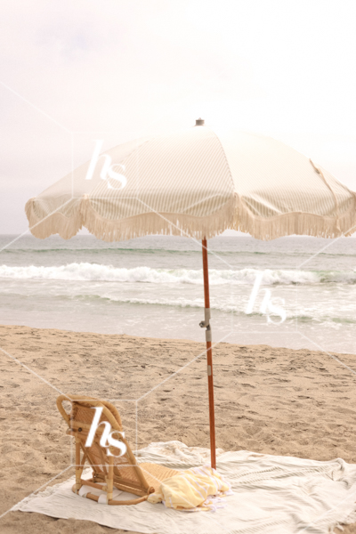 stock image of Vintage beach blanket and umbrella on beachpart of Beach Babe collection, costal stock photos & videos perfect for summer travel enthusiasts.