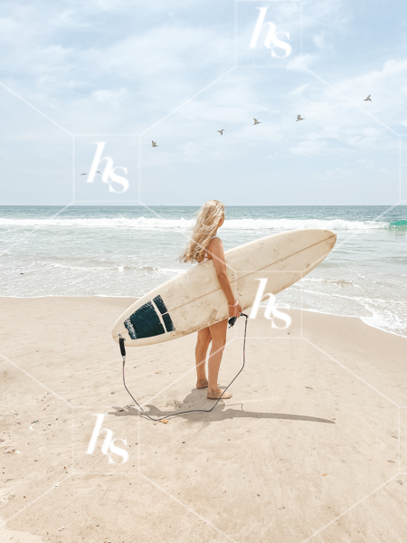 Woman on the beach getting ready to surf, part of Beach Babe collection, costal stock photos & videos perfect for summer travel enthusiasts.