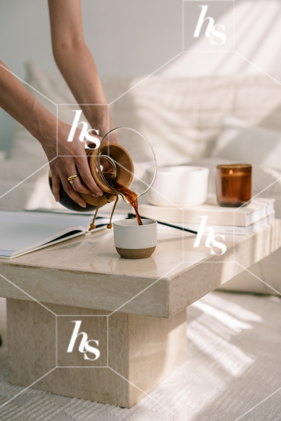 Woman pouring black coffee into mug from carafe, part of Blank space collection of workspace & interior stock imagery