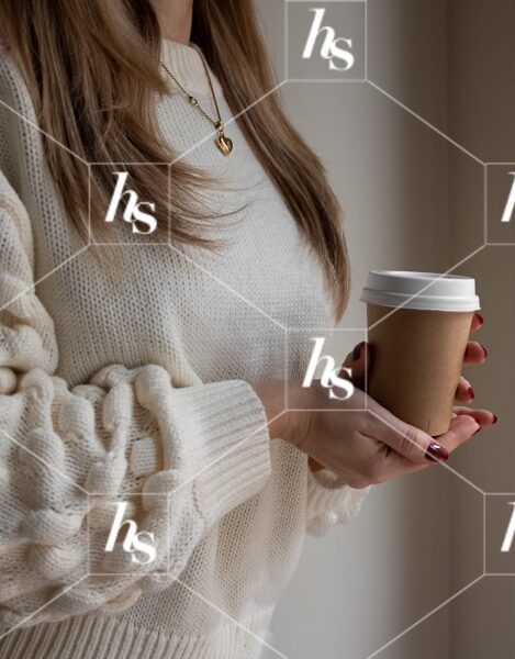 Woman holding a warm cup of coffee as she gets cozy inside, part of Gingerbread cozy holiday stock images collection by Haute Stock