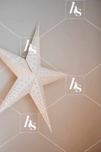 Large paper star on wall, part of Gingerbread cozy holiday stock images collection by Haute Stock