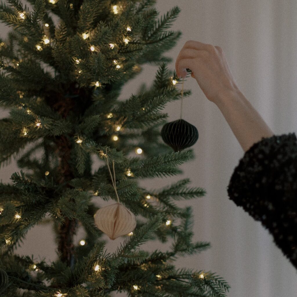 Model decorating the Christmas with paper ornaments, this stock image captures the festive spirit, and holiday charm.





