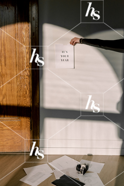 Woman holding a sign to the wall that reads "It's Your Year", part of Haute Stock's manifesting stock images collection