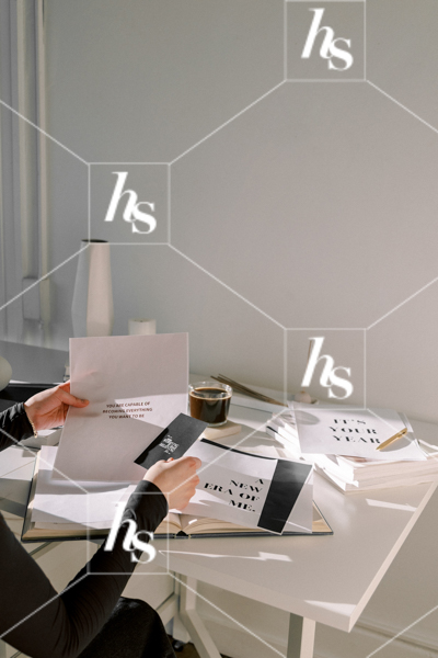 Woman sorting through inspirational quotes for her mood board, part of Haute Stock's manifesting stock images collection