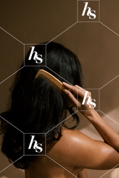An image of woman brushing her long, thick black hair, part of wellness brands visuals