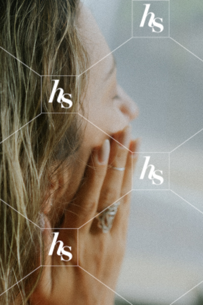 A close-up of a woman gently touching her face, suggesting self-care and relaxation.