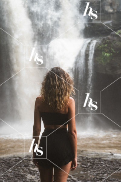 Woman standing by a waterfall, part of Mist: Self-love & travel aesthetic imagery.