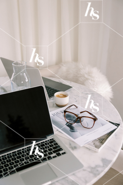 Close-up of the laptops on marble desk used by coworkers for an epic team strategy day, part of collaboration stock imagery collection by Haute Stock