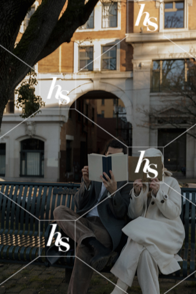 Chic and Romantic image of a couple sitting on a bench in the city reading books. Part of Haute Stock's Urban Couple collection.