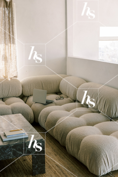 Working from the comfort of a cozy boucle couch, part of Drift collection of desert and interior stock images 