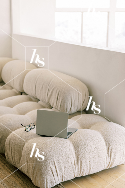 Laptop and reading glasses on boucle couch, part of Drift collection - desert and interior stock imagery by Haute Stock