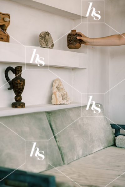Woman styling stone shelf with earthy and bohemian decor, part of Drift collection - desert and interior stock imagery by Haute Stock