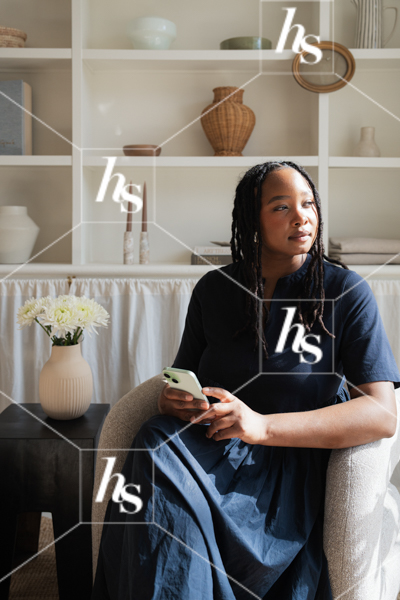 Woman sitting in chair gazing out into the sunlight, part of Anthology a collection of interior-inspired stock photos for creative studios, designers, and lifestyle brands.