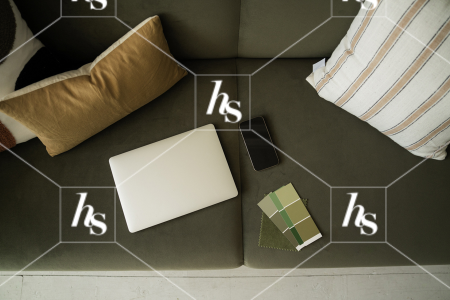 a stock image of Laptop, phone, and swatches laid out on green couch, part of a collection of interior-inspired stock photos for creative studios, designers, and lifestyle brands.