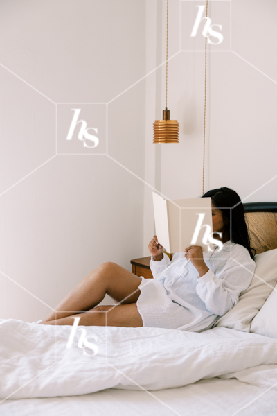Woman reading a book in bed with natural morning light. Wellness stock photos for self-care routines, lifestyle bloggers, and intentional living content.