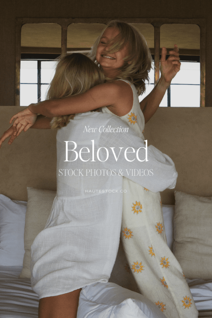 A blonde mother in a white linen shirt tightly holds and hugs her laughing young daughter. Overlay text reads New Collection Beloved Stock Photos and Videos.